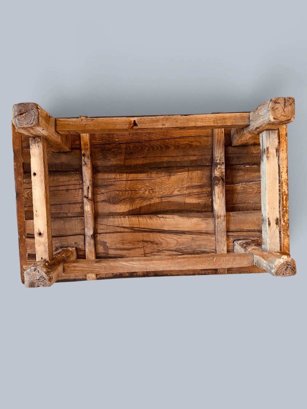 A low rustic pine market table featuring thick block legs, exposed mortise and tenon joinery, and a weathered wood top. View VIII