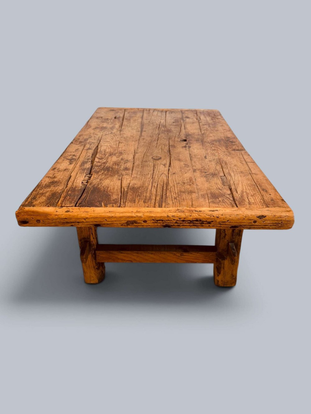 A low rustic pine market table featuring thick block legs, exposed mortise and tenon joinery, and a weathered wood top. View X