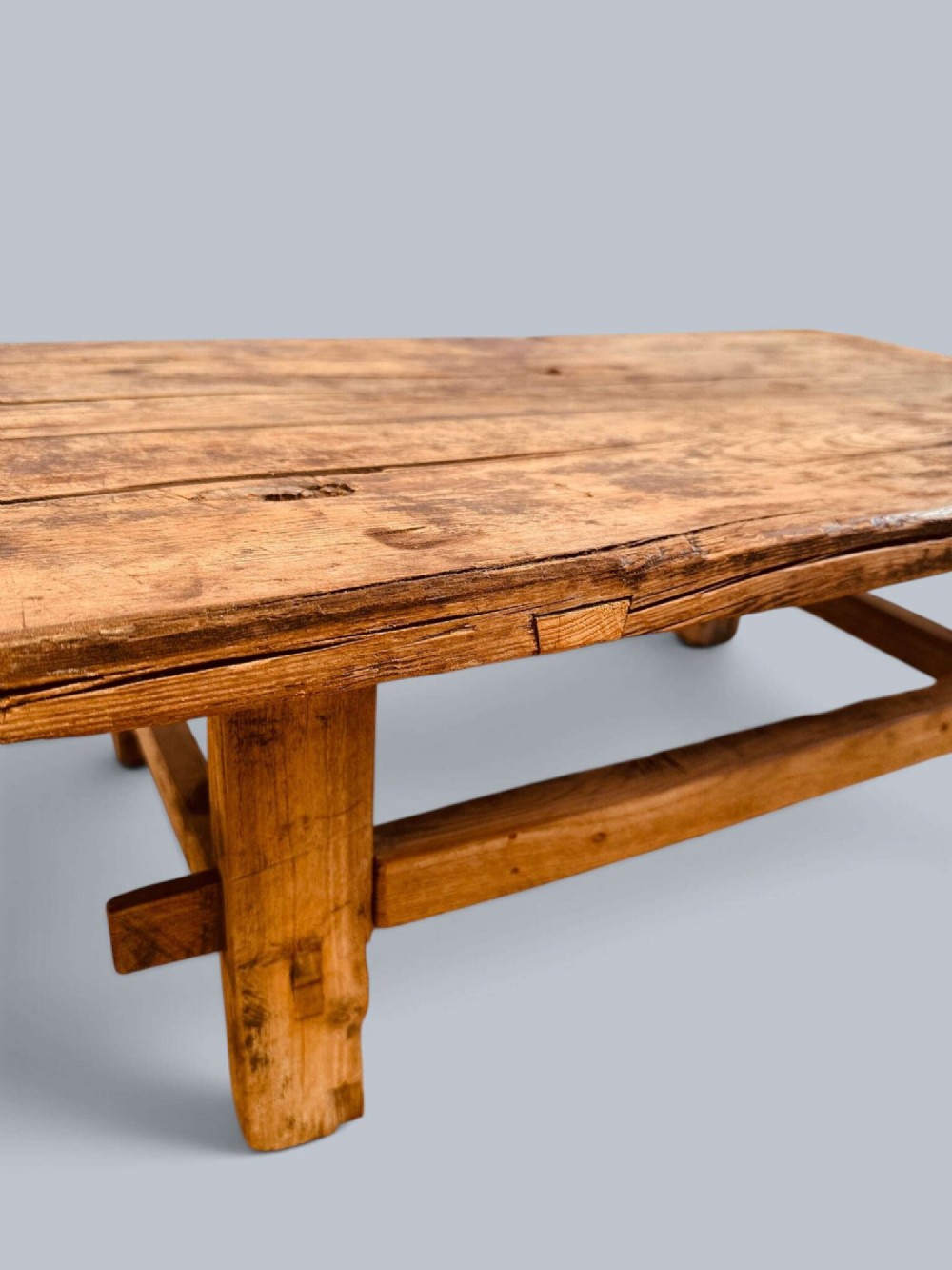 A low rustic pine market table featuring thick block legs, exposed mortise and tenon joinery, and a weathered wood top. View XI