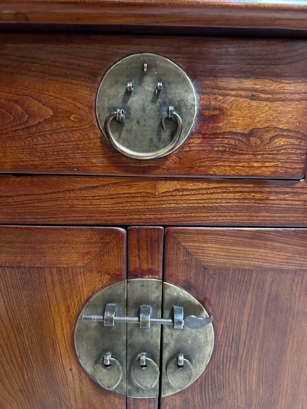 A warm brown Chinese elm altar cabinet featuring three upper drawers, two central cupboard doors, and round brass hardware. View III