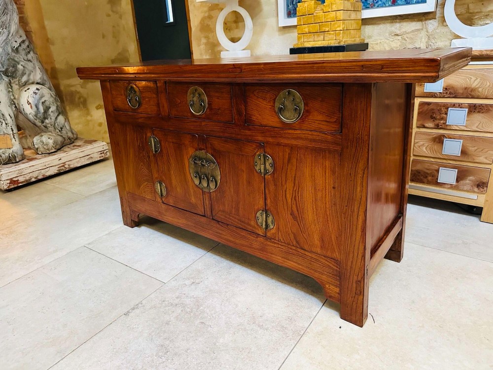 A warm brown Chinese elm altar cabinet featuring three upper drawers, two central cupboard doors, and round brass hardware. View VI
