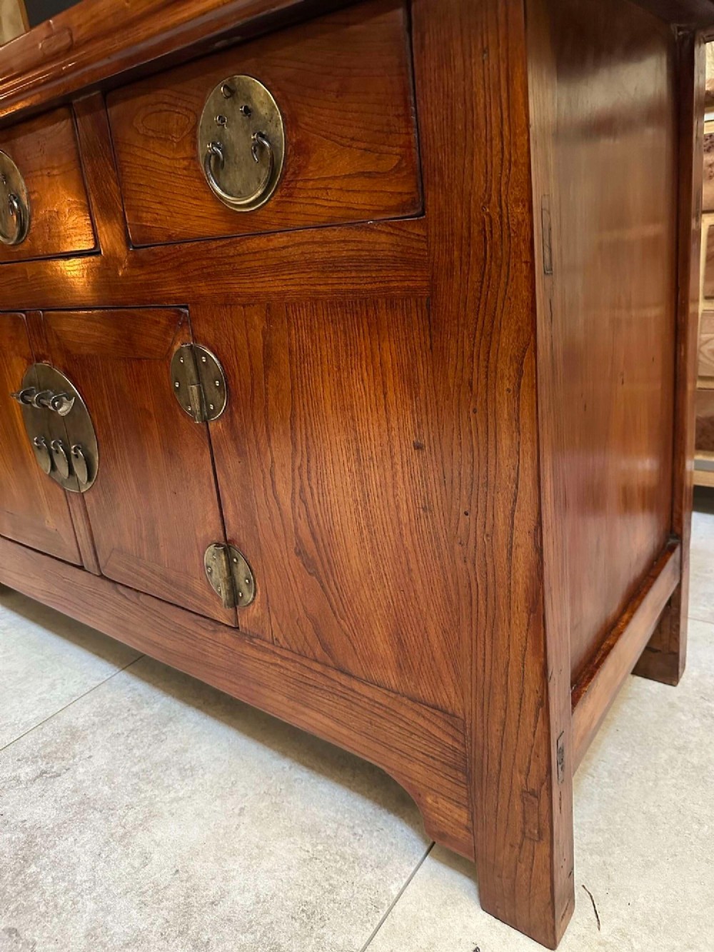 A warm brown Chinese elm altar cabinet featuring three upper drawers, two central cupboard doors, and round brass hardware. View XIII