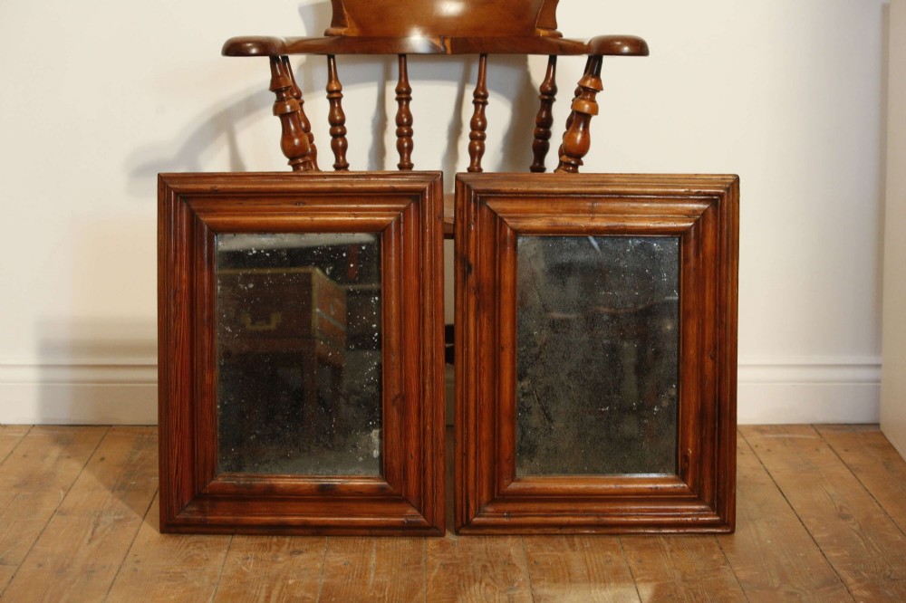 A pair of matching rectangular wall mirrors with deep moulded pine frames and distressed glass plates.