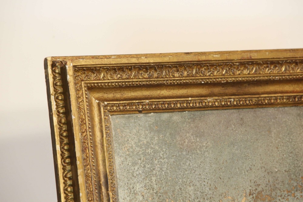 A 19th-century French rectangular giltwood wall mirror featuring a moulded frame with detailed borders and a heavily foxed glass plate. View IV