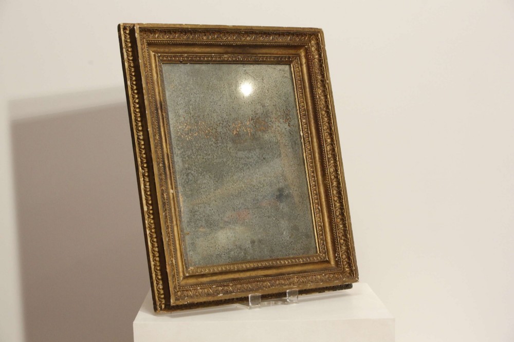 A 19th-century French rectangular giltwood wall mirror featuring a moulded frame with detailed borders and a heavily foxed glass plate. View V