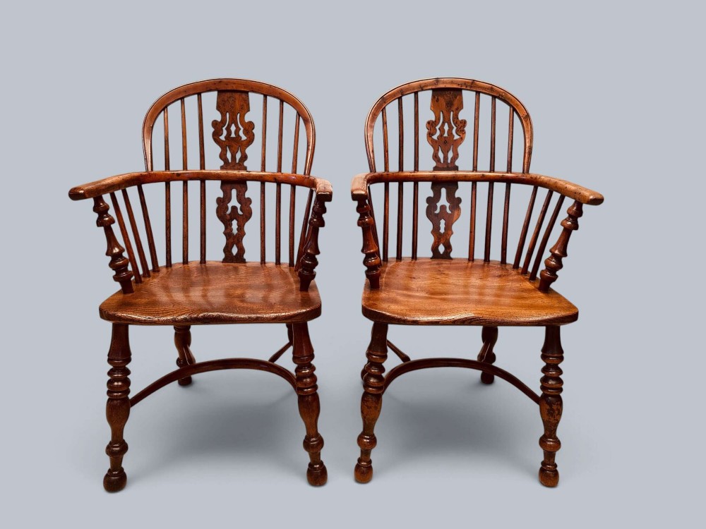 A pair of 19th-century yew wood Windsor armchairs featuring low hoop backs, pierced central splats, turned spindle supports, and shaped seats. View II