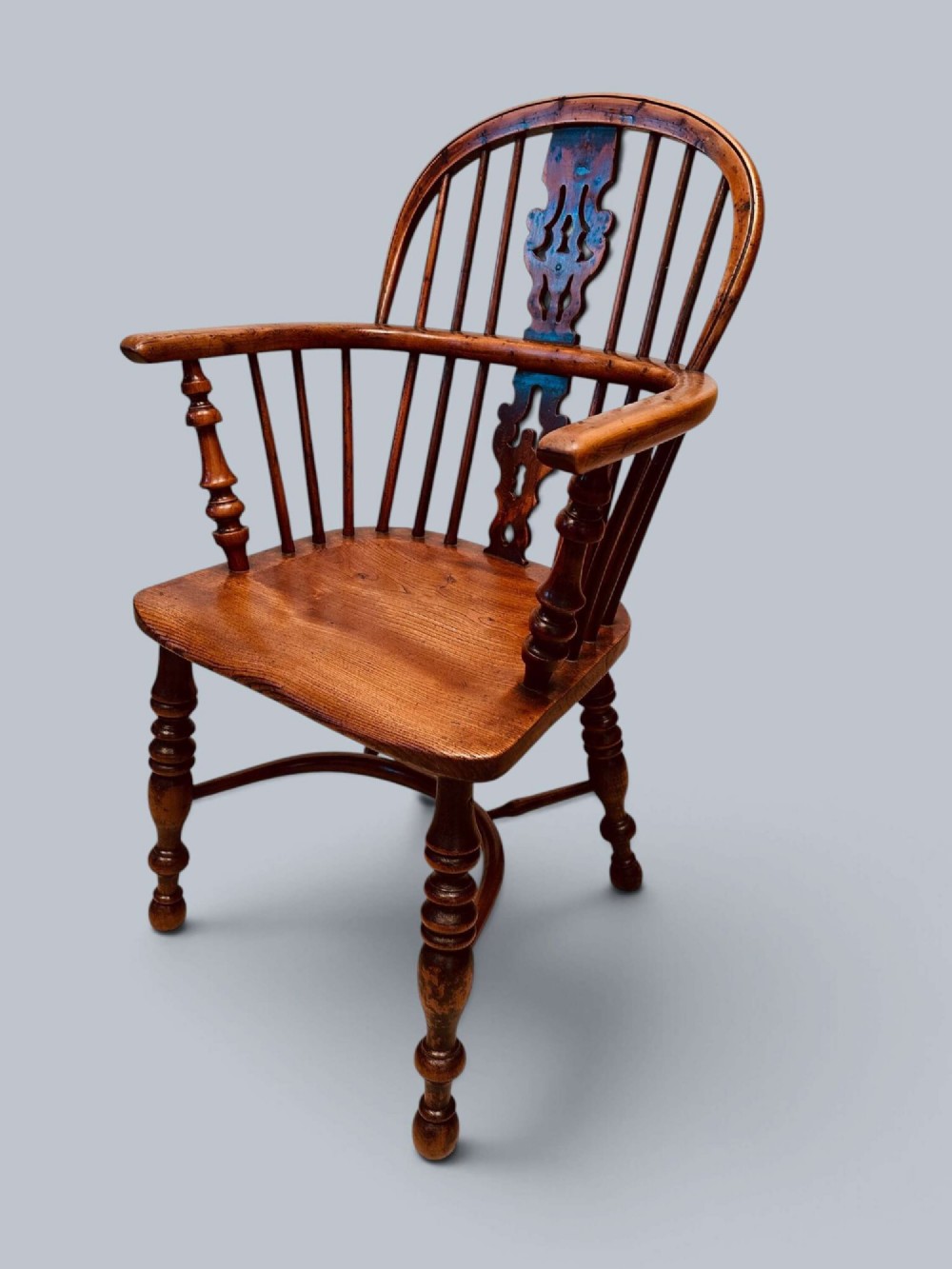 A pair of 19th-century yew wood Windsor armchairs featuring low hoop backs, pierced central splats, turned spindle supports, and shaped seats. View IV