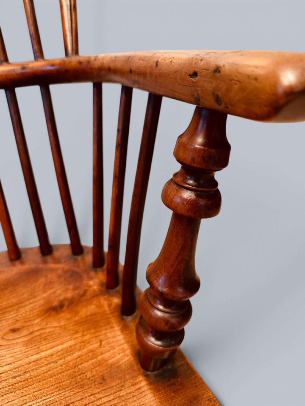 A pair of 19th-century yew wood Windsor armchairs featuring low hoop backs, pierced central splats, turned spindle supports, and shaped seats. View VIII