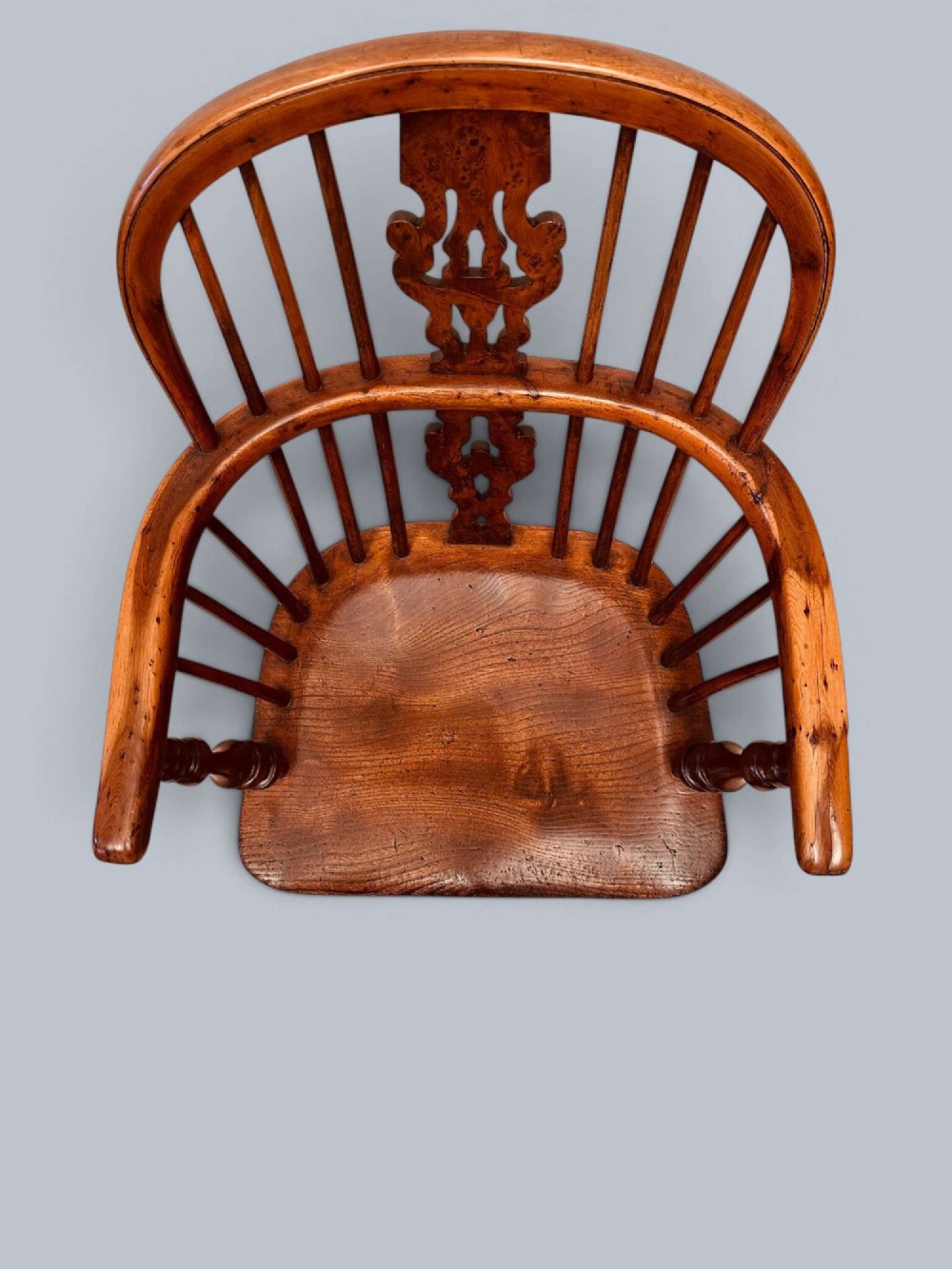 A pair of 19th-century yew wood Windsor armchairs featuring low hoop backs, pierced central splats, turned spindle supports, and shaped seats. View XIII