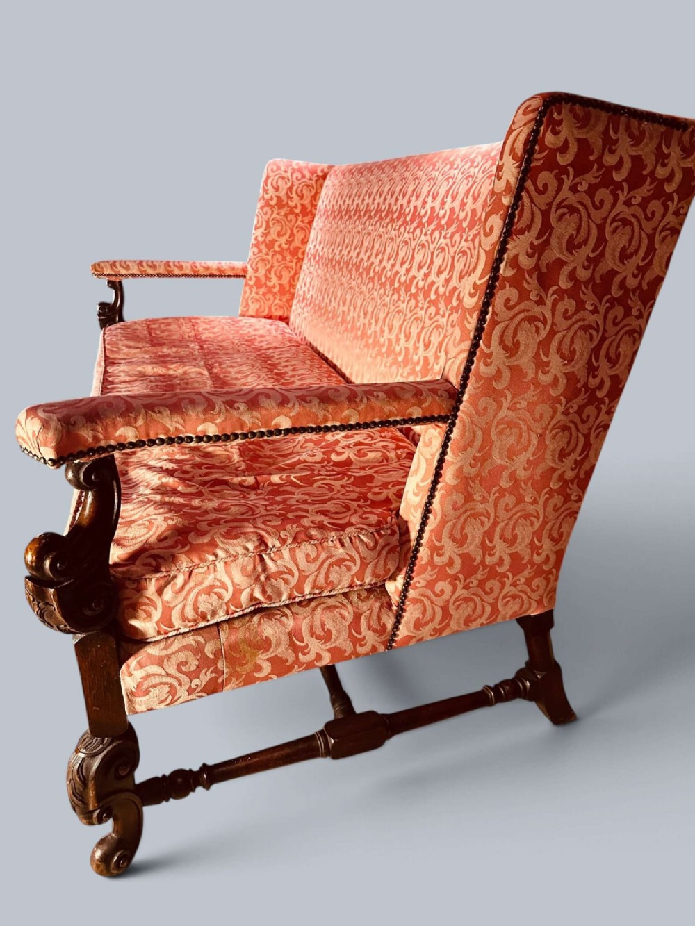 Late 19th-century Louis XIV style walnut sofa with intricately carved stretchers and red patterned damask fabric. View IV