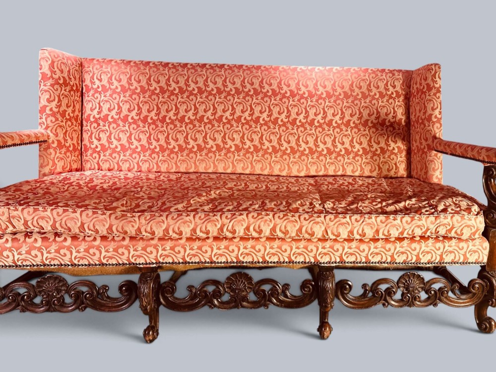 Late 19th-century Louis XIV style walnut sofa with intricately carved stretchers and red patterned damask fabric. View V