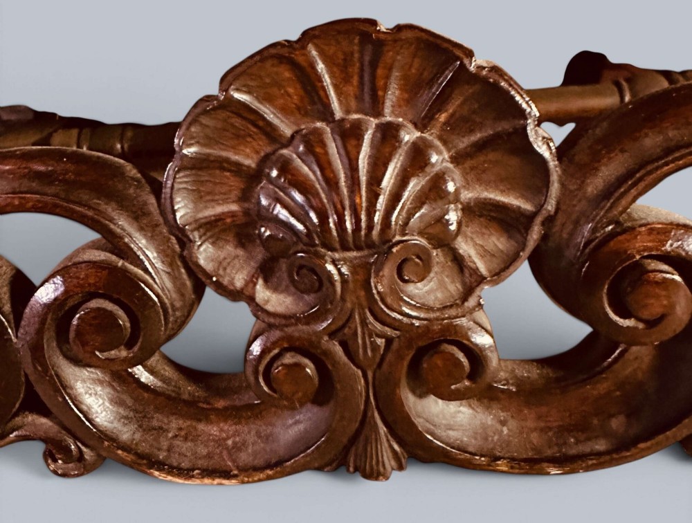 Late 19th-century Louis XIV style walnut sofa with intricately carved stretchers and red patterned damask fabric. View XIV