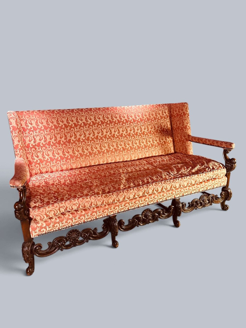 Late 19th-century Louis XIV style walnut sofa with intricately carved stretchers and red patterned damask fabric. View XV