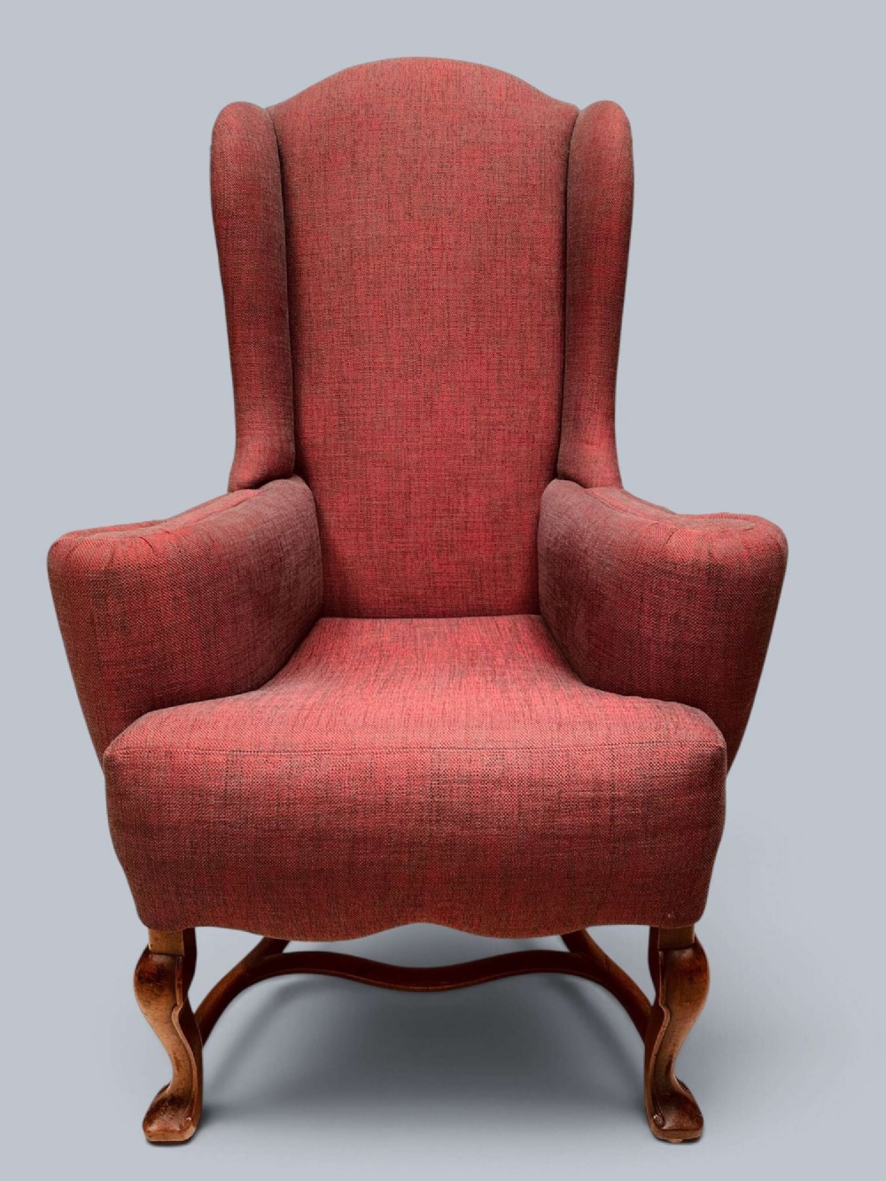 A high-backed Queen Anne style wing armchair upholstered in burgundy textured fabric with walnut cabriole front legs and curved stretchers. View III