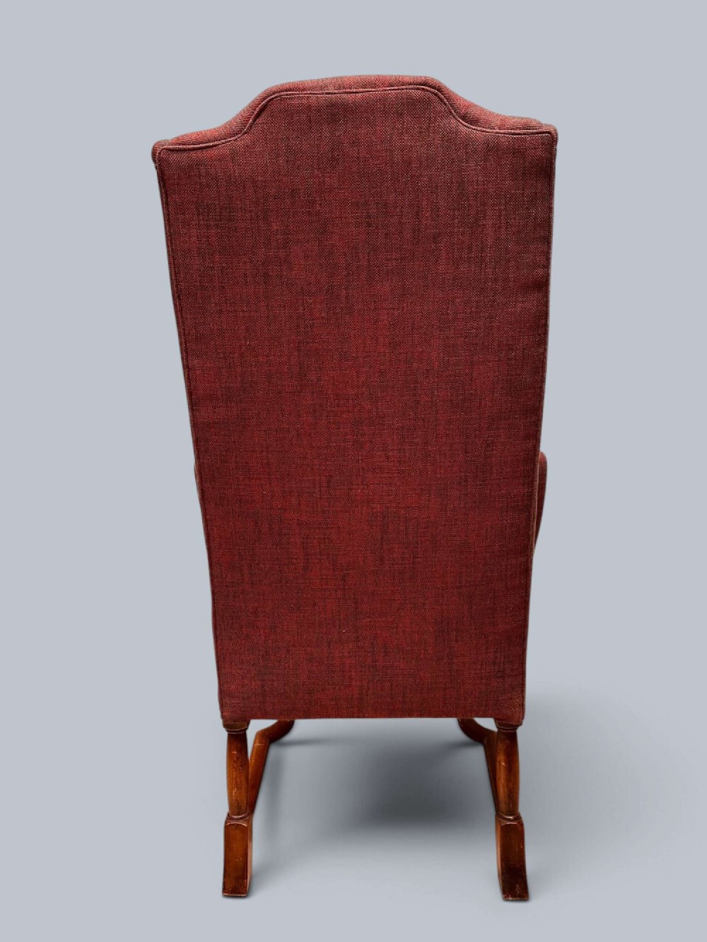 A high-backed Queen Anne style wing armchair upholstered in burgundy textured fabric with walnut cabriole front legs and curved stretchers. View VI