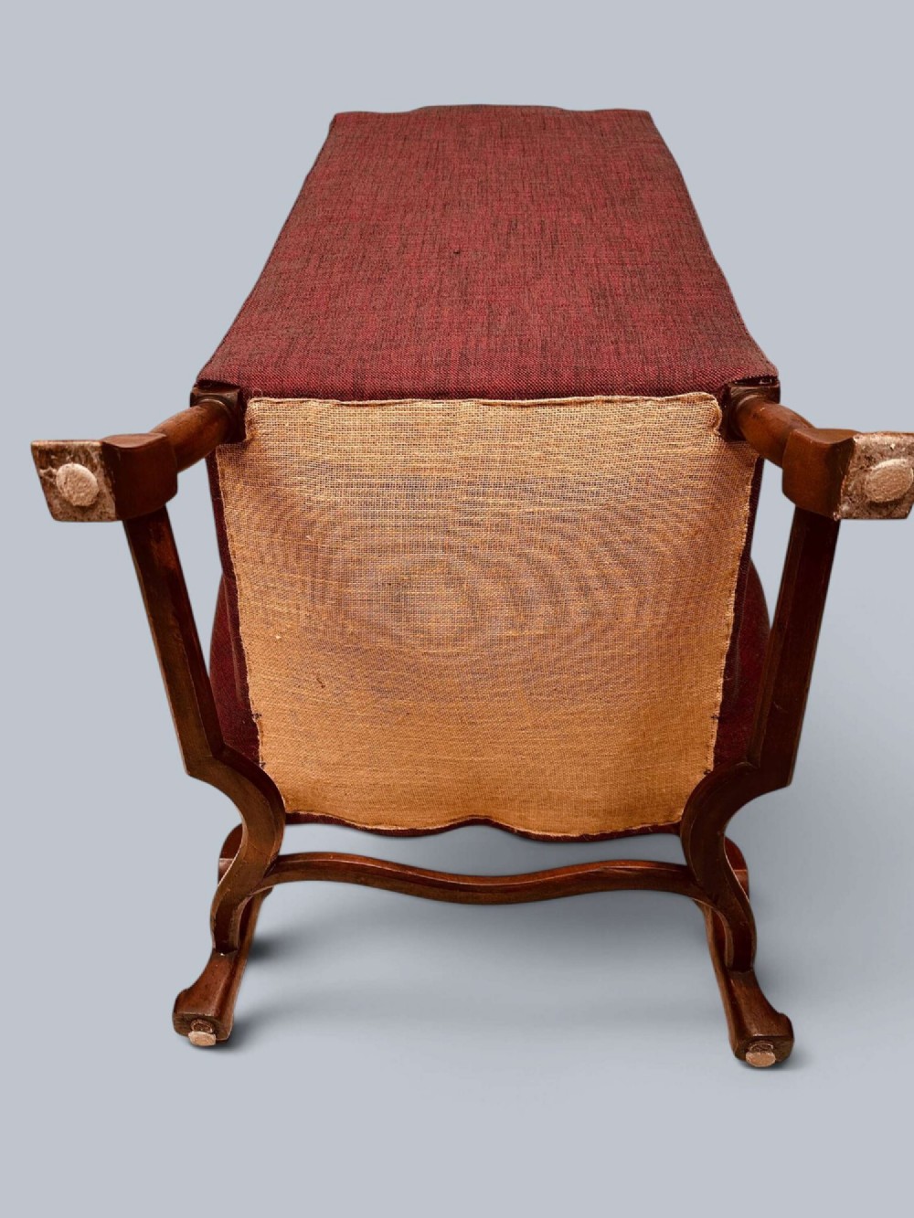 A high-backed Queen Anne style wing armchair upholstered in burgundy textured fabric with walnut cabriole front legs and curved stretchers. View XII