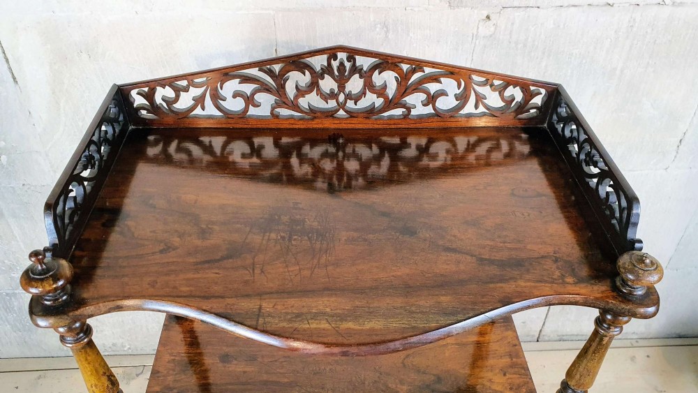 A three-tiered Victorian rosewood whatnot featuring turned spindle supports, serpentine-fronted shelves, and a decorative pierced fretwork top gallery. View VI
