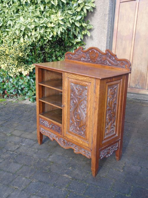 Arts & Crafts cabinet carved with fish and flowers