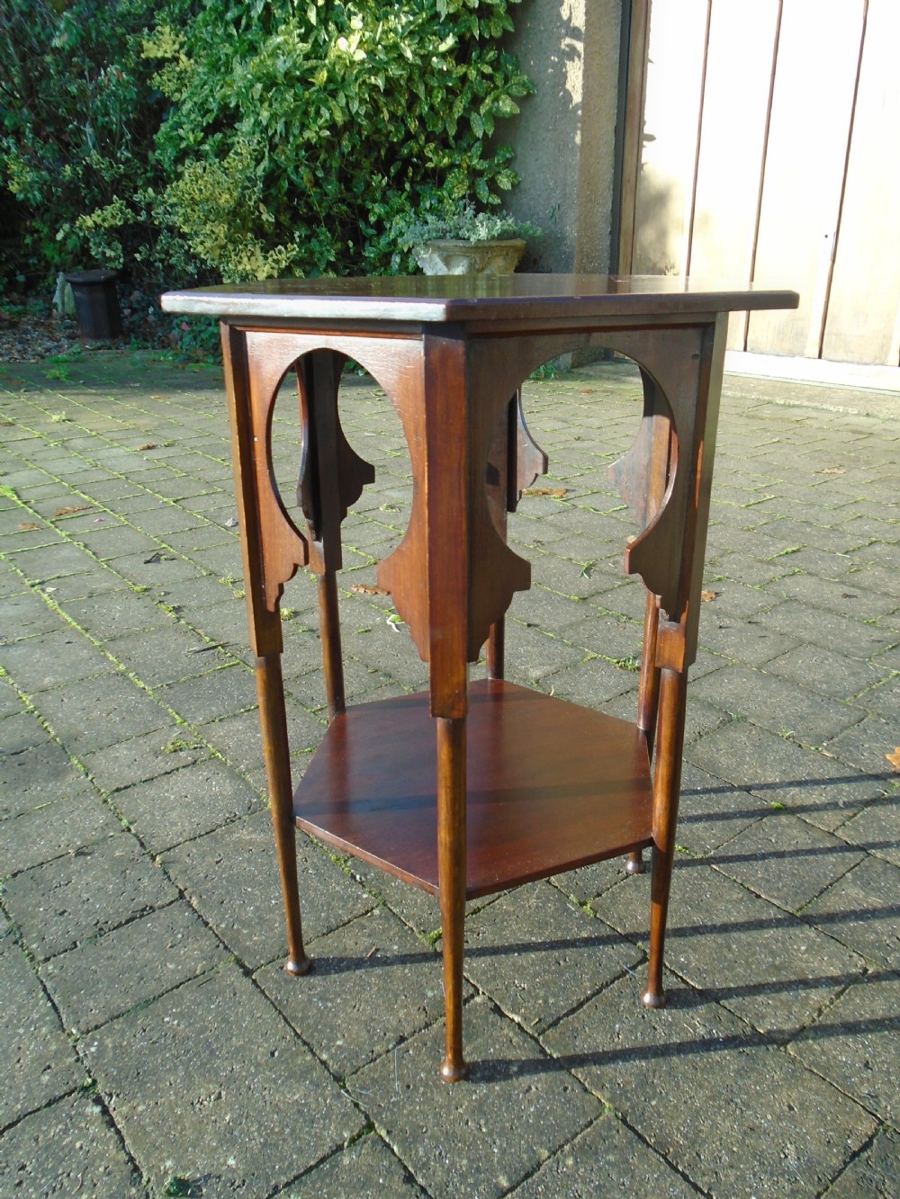 A hexagonal walnut side table featuring carved Moorish horseshoe arches, turned legs, and a lower hexagonal tier. View II
