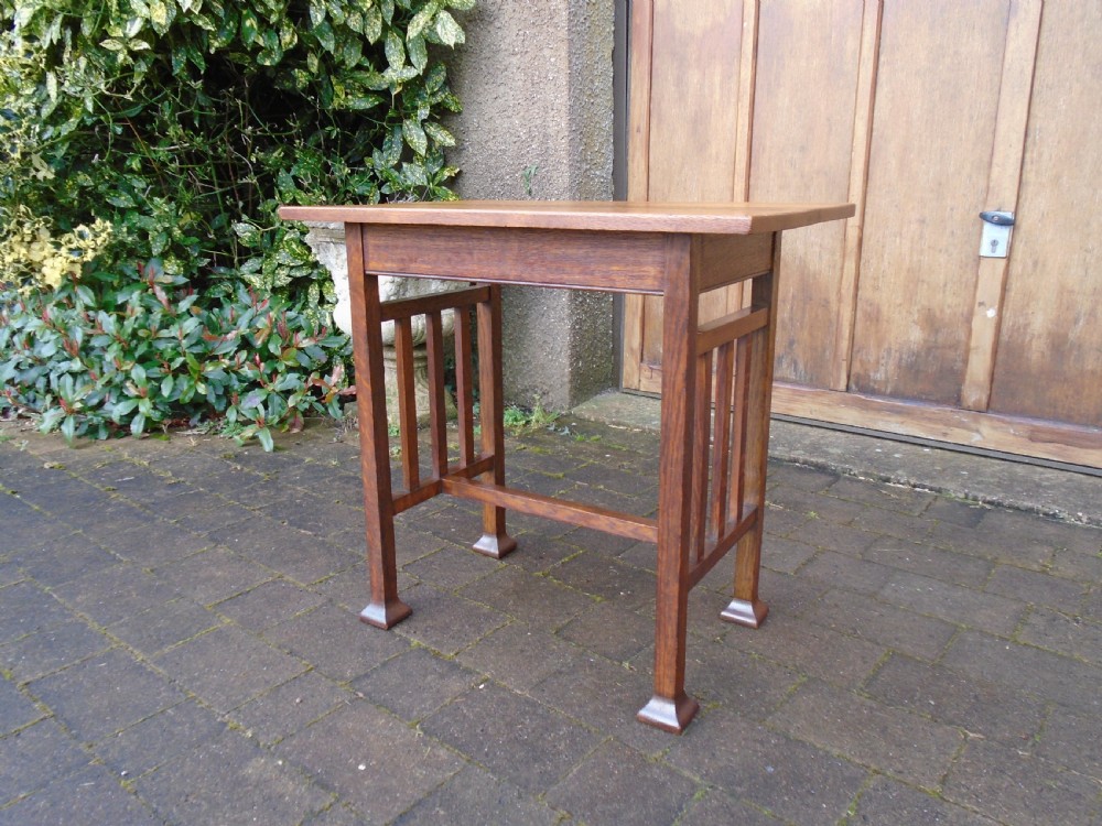 A rectangular Arts and Crafts oak side table featuring slatted side stretchers, square legs with splayed feet, and a flat top. View III