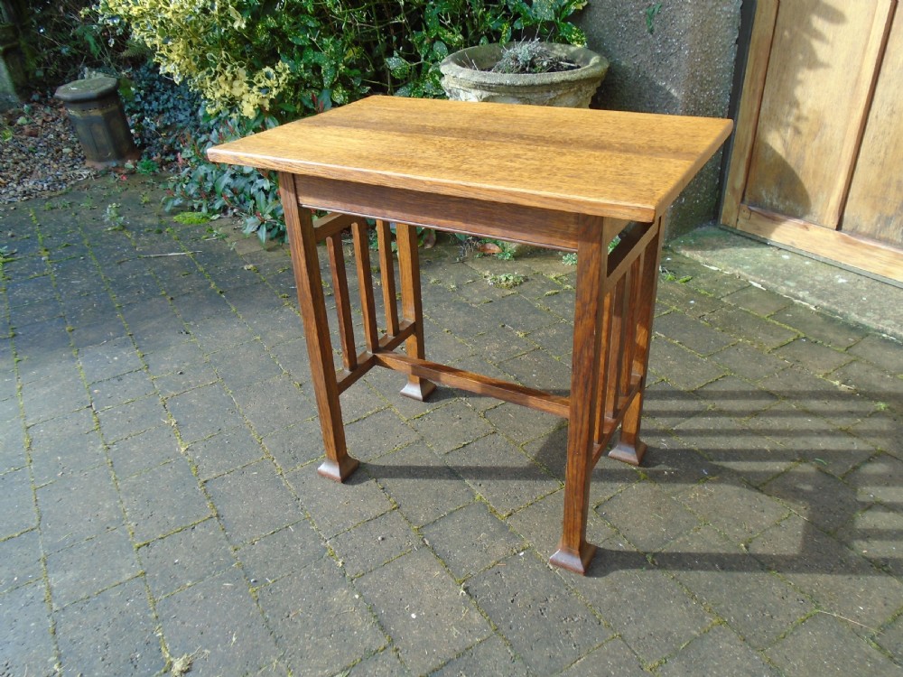 A rectangular Arts and Crafts oak side table featuring slatted side stretchers, square legs with splayed feet, and a flat top. View V