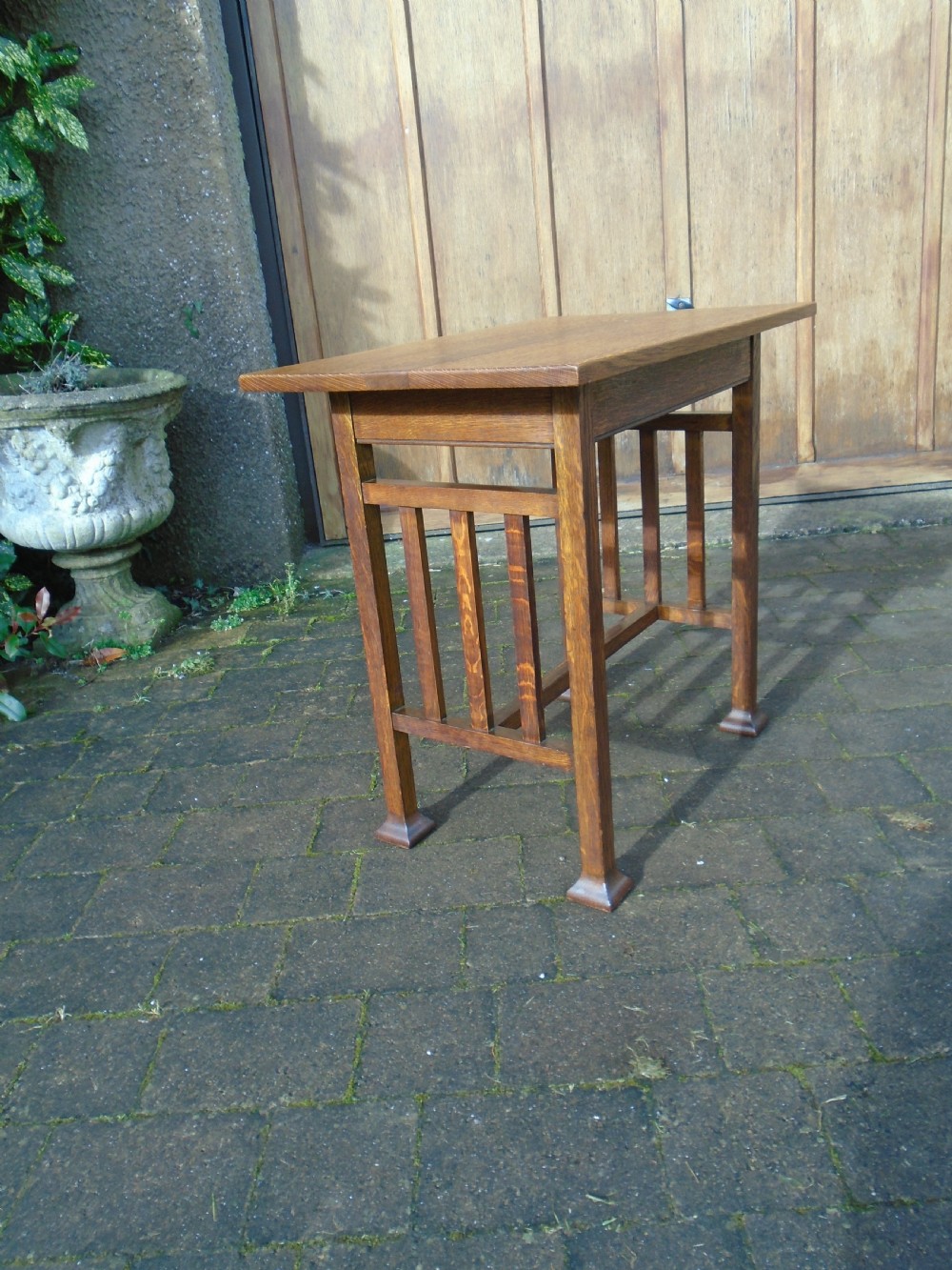 A rectangular Arts and Crafts oak side table featuring slatted side stretchers, square legs with splayed feet, and a flat top. View VI