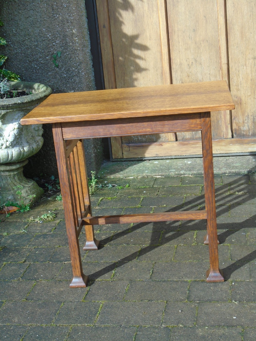 A rectangular Arts and Crafts oak side table featuring slatted side stretchers, square legs with splayed feet, and a flat top. View VIII