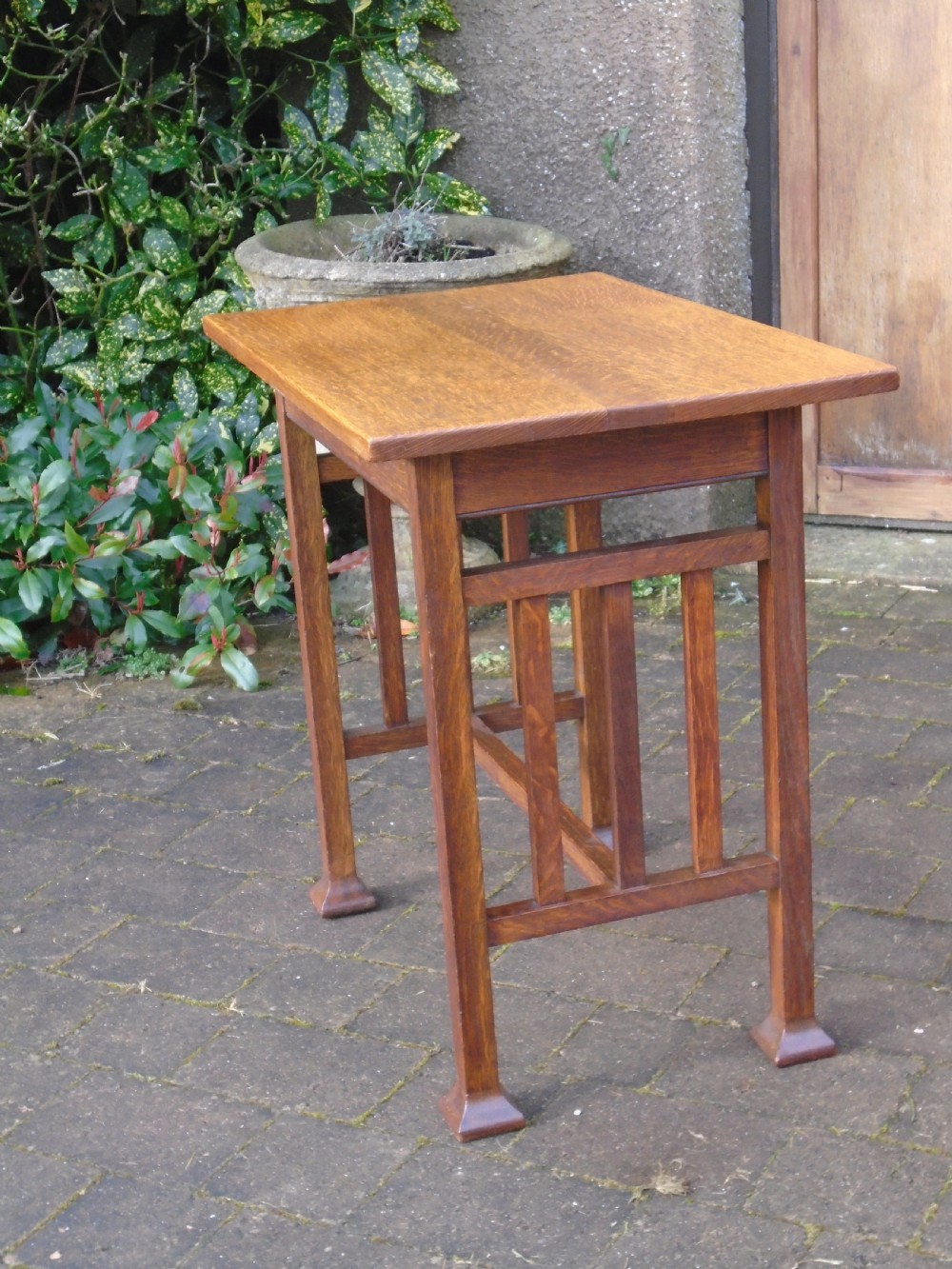 A rectangular Arts and Crafts oak side table featuring slatted side stretchers, square legs with splayed feet, and a flat top. View X