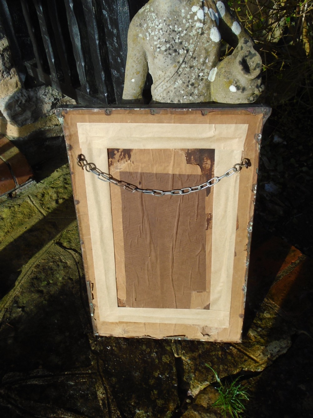 A rectangular Arts and Crafts wall mirror featuring a beaten copper frame with riveted corners and embossed tulip motifs along the side panels. View VIII