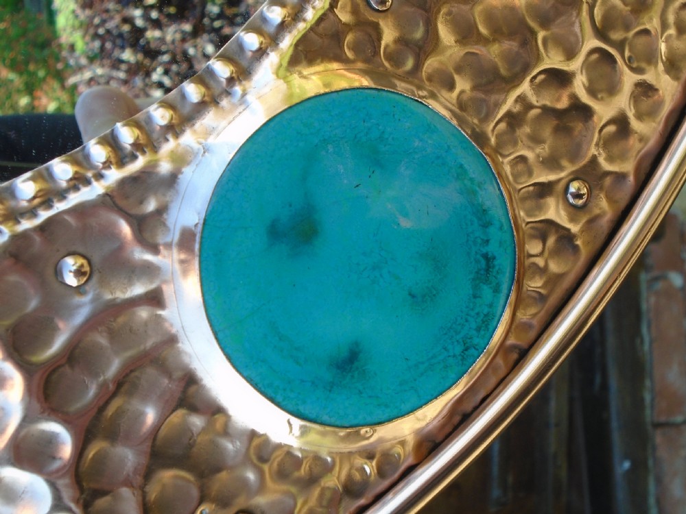 An oval Arts and Crafts wall mirror featuring a hand-hammered copper frame decorated with repousse floral motifs and four turquoise round cabochons. View VIII