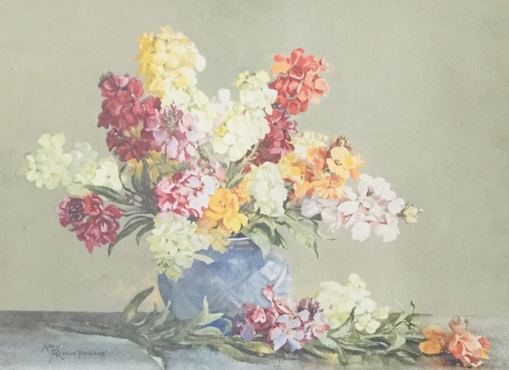 A watercolour painting depicting a vibrant arrangement of yellow, red, pink, and cream wallflowers in a round blue vase resting on a flat surface against a muted green background.