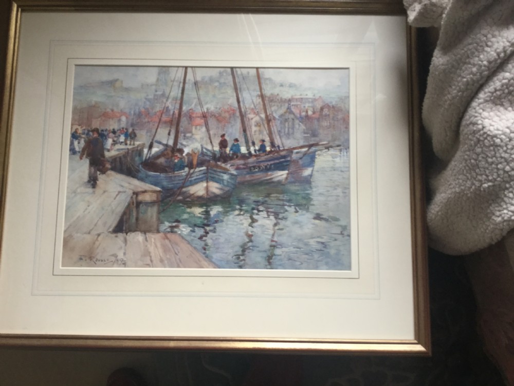 A late 19th-century watercolour painting depicting fishing boats docked at a harbour quay in Whitby with town buildings visible in the background. View II