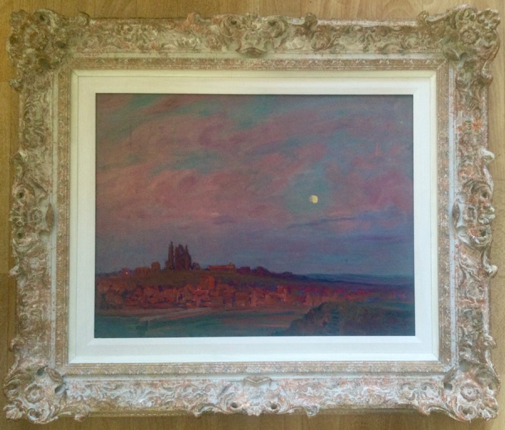An impressionist oil painting depicting Whitby Abbey silhouetted against a twilight sky in shades of purple and pink, presented in an ornate carved frame.