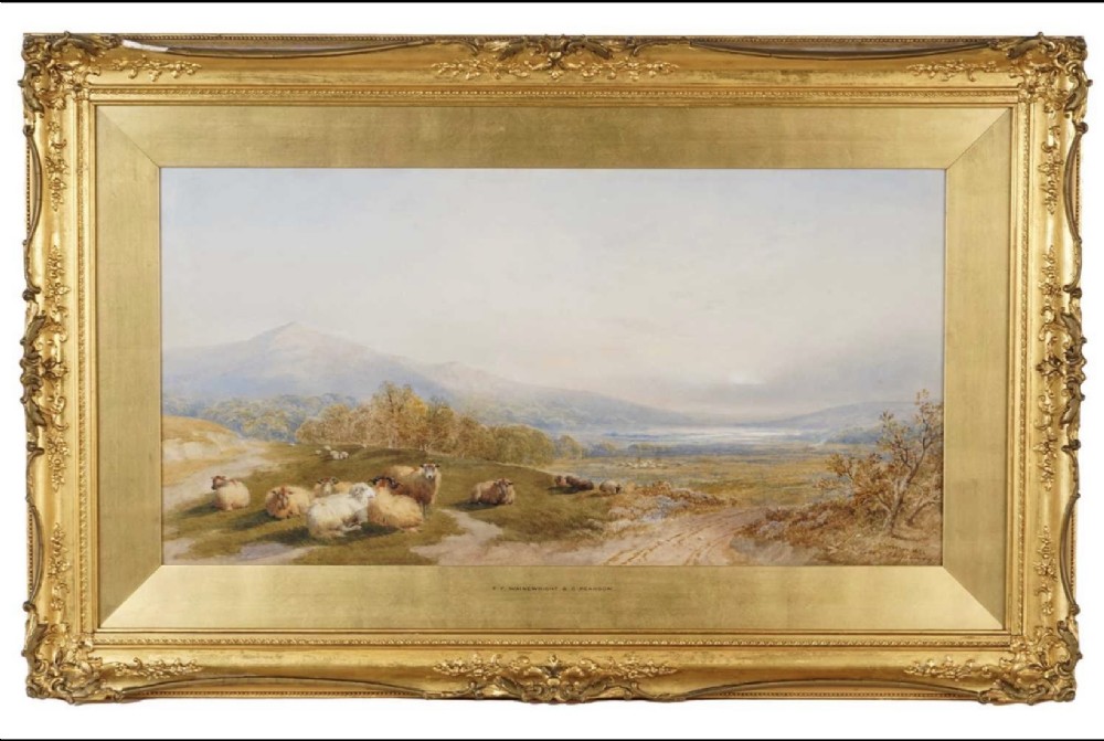 A framed nineteenth-century Victorian watercolour landscape painting depicting a flock of sheep resting on a hill before a mountainous landscape, framed in an ornate gilded wood frame.