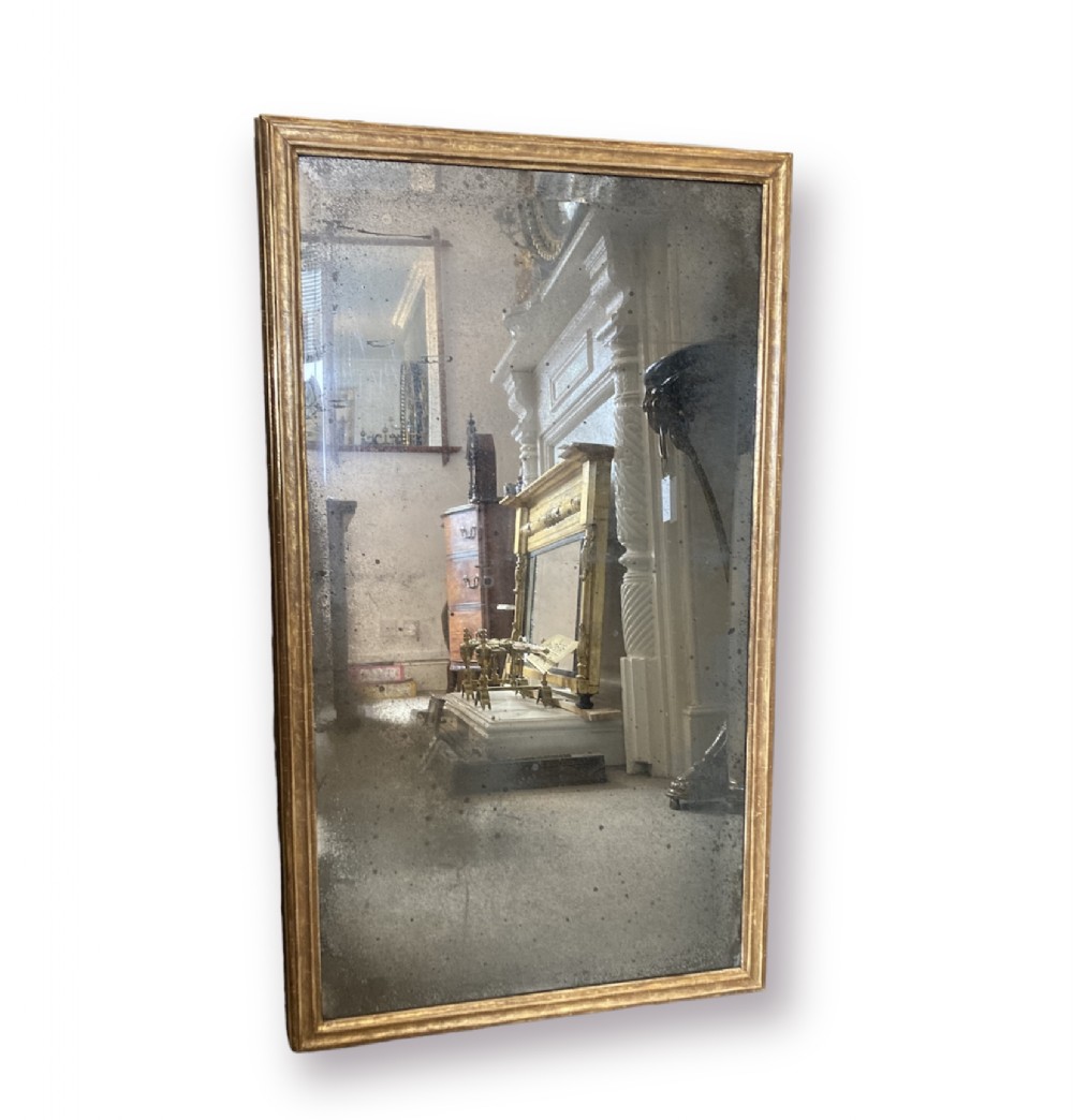A rectangular 19th-century wall mirror with a narrow giltwood frame and a mercury glass plate showing age-related foxing.