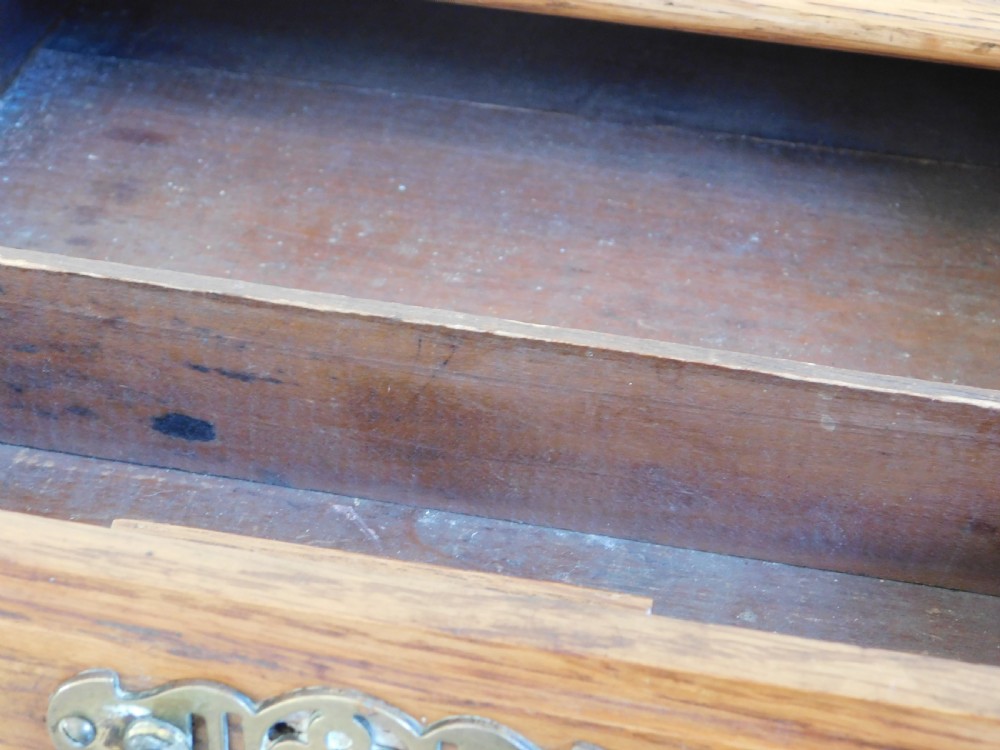 A Victorian oak writing table featuring two drawers with brass drop handles and curved leg braces. View III