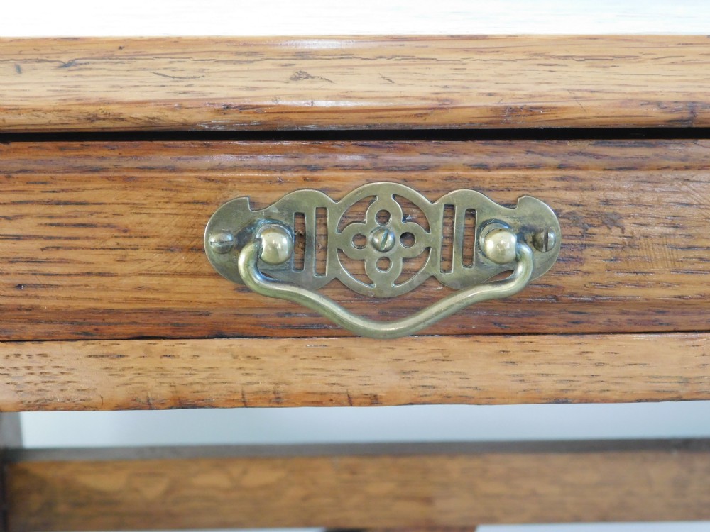 A Victorian oak writing table featuring two drawers with brass drop handles and curved leg braces. View IV