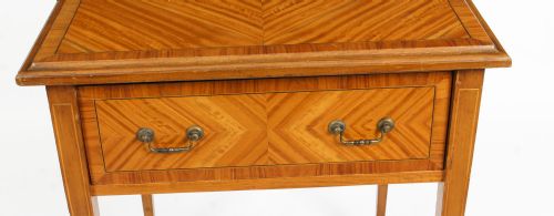 fig 2. A square Victorian satinwood occasional table featuring a single drawer with brass handles, chevron parquetry top, and four square tapered legs.