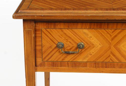fig 3. A square Victorian satinwood occasional table featuring a single drawer with brass handles, chevron parquetry top, and four square tapered legs.