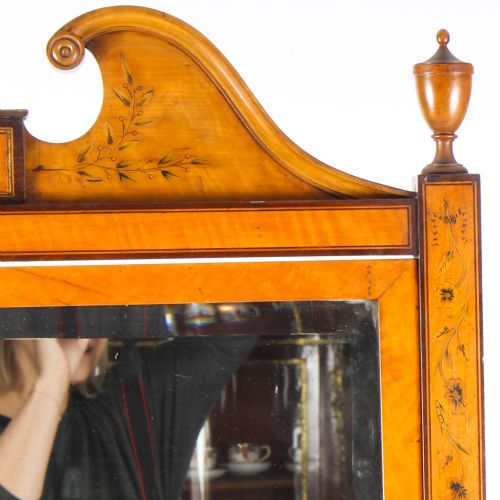 fig 4. An Edwardian satinwood cheval mirror featuring intricate marquetry inlay, an arched pediment with finials, side adjusters, and splayed legs with brass castors.