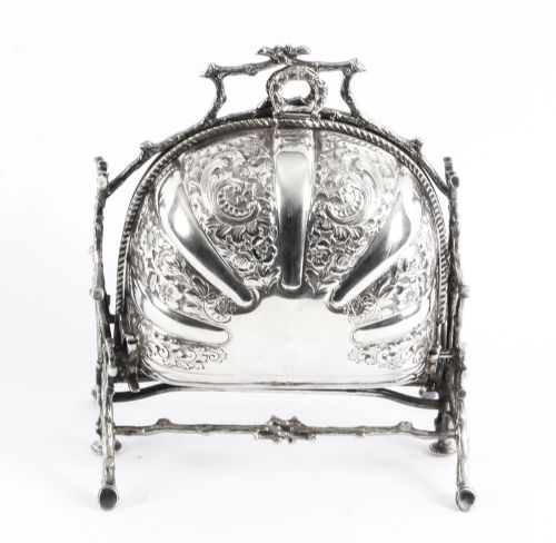 fig 1. An antique silver-plated folding biscuit box featuring two chased shell-shaped compartments mounted on a cast faux-branch frame.