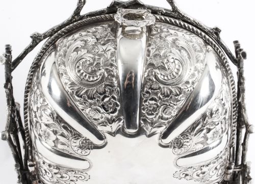 fig 2. An antique silver-plated folding biscuit box featuring two chased shell-shaped compartments mounted on a cast faux-branch frame.