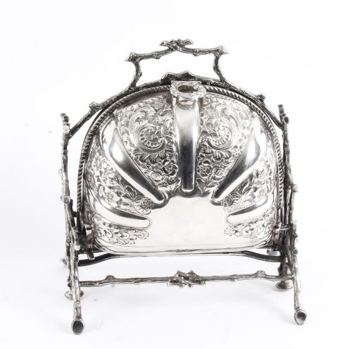 fig 4. An antique silver-plated folding biscuit box featuring two chased shell-shaped compartments mounted on a cast faux-branch frame.