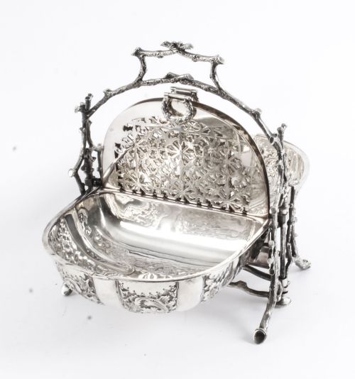 fig 5. An antique silver-plated folding biscuit box featuring two chased shell-shaped compartments mounted on a cast faux-branch frame.