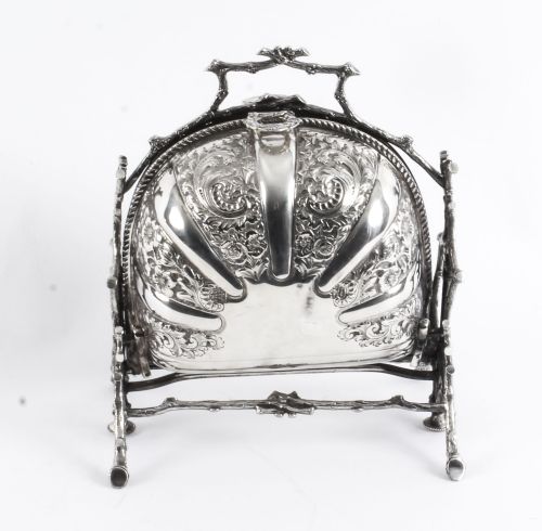 fig 6. An antique silver-plated folding biscuit box featuring two chased shell-shaped compartments mounted on a cast faux-branch frame.