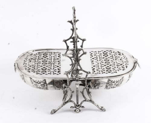 fig 7. An antique silver-plated folding biscuit box featuring two chased shell-shaped compartments mounted on a cast faux-branch frame.