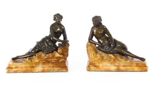 fig 1. A pair of 19th-century dark bronze sculptures depicting semi-nude classical reclining female figures set upon carved yellow marble bases.