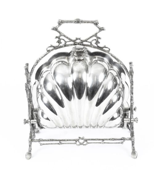 fig 1. An antique Victorian silver-plated folding biscuit box shaped like a double scallop shell suspended in a twig-form metal frame.
