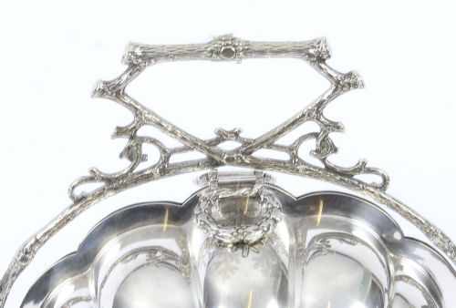 fig 2. An antique Victorian silver-plated folding biscuit box shaped like a double scallop shell suspended in a twig-form metal frame.
