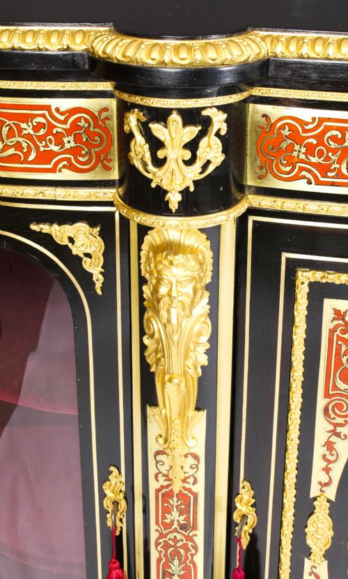 fig 7. A nineteenth-century ebonised serpentine credenza featuring brass and tortoiseshell Boulle marquetry, cast gilt-bronze ormolu mounts, a central panelled door, and glass display sides.